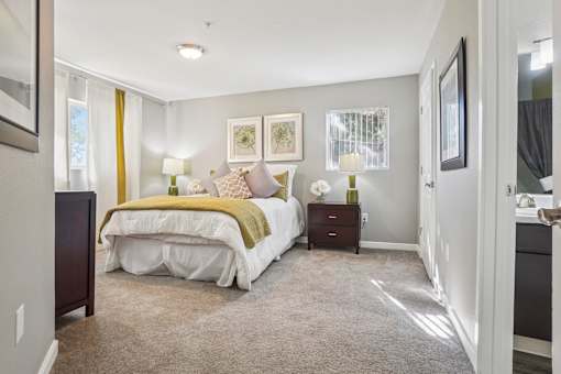A bedroom with a bed, nightstand, and two lamps.