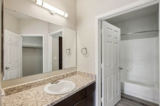 A bathroom with a sink, mirror, and bathtub at Sweetwater At Metro North Apartments, Phoenix, AZ