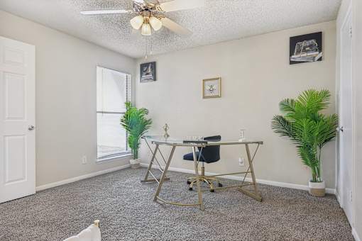 a home office with a desk and a ceiling fan at The Glen at Highpoint, Dallas, 75243