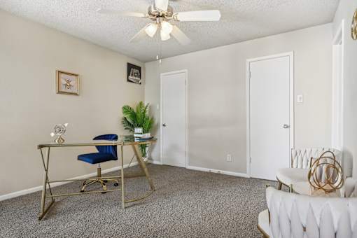a living room with a desk and a ceiling fan at The Glen at Highpoint, Dallas, 75243