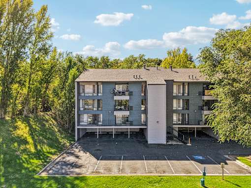 A large apartment complex with a parking lot in front at Cliffs at Canyon Ridge, Ogden, UT, 84401