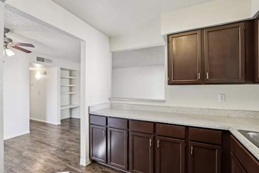 A kitchen with brown cabinets and a white counter at Del Coronado Apartment, Mesa, AZ, 85202