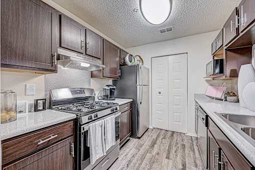 a kitchen with wood cabinets and stainless steel appliances at St. Johns Forest Apartments, Florida, 32277