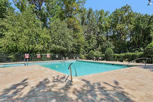 A pool surrounded by trees and a black fence. at Canopy Glen, Norcross, GA, 30093