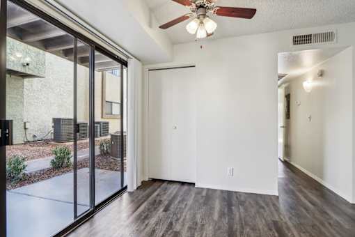 A room with a ceiling fan and sliding glass doors at Del Coronado Apartment , Mesa, 85202