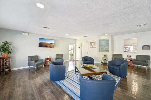 A living room with a blue couch and a wooden coffee table. at Sarasota South Apartments, Bradenton, FL, 34207