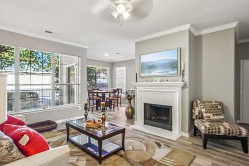 A living room with a fireplace and a painting on the wall. at Bridford Lake Apartments, North Carolina