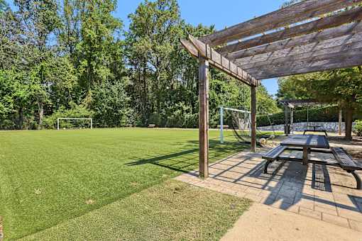 A wooden pergola is over a picnic table in a park. at Canopy Glen, Norcross, GA, 30093