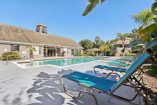 Swimming pool area with spa and clubhouse at The Arbor Walk Apartments, Tampa, FL