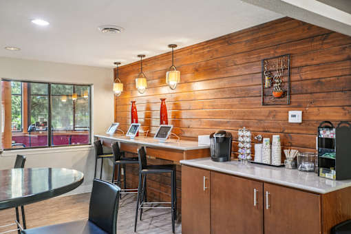A modern kitchen with wooden walls and a glass table. at University Village Apartments, Colorado, 80918