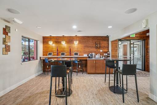 A modern kitchen with a wooden wall and bar stools. at University Village Apartments, Colorado