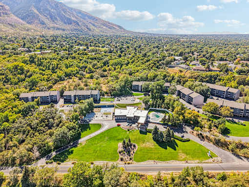 A large building complex surrounded by trees and a green lawn at Cliffs at Canyon Ridge, Ogden, UT, 84401