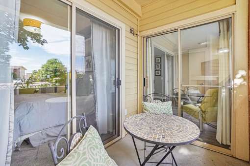 A patio with a table and chairs is visible through a sliding glass door.