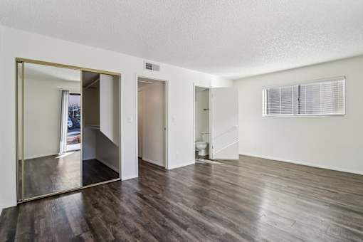 A large empty room with wooden floors and a large mirror on the wall at Del Coronado Apartment , Arizona, 85202