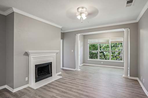A room with a fireplace and sliding glass doors at Bridford Lake Apartments, Greensboro