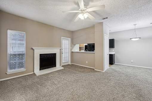 A living room with a fireplace and a ceiling fan.