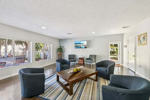 A living room with a large couch, a chair, and a coffee table. at Sarasota South Apartments, Florida