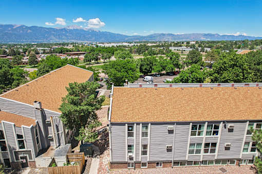 A view of a residential area with apartment buildings and a mountain range in the distance.