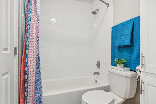 a bathroom with a shower curtain and a toilet at The Glen at Highpoint, Dallas, 75243