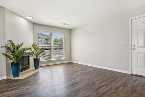an empty living room with a window and a door at The Glen at Highpoint, Dallas, 75243