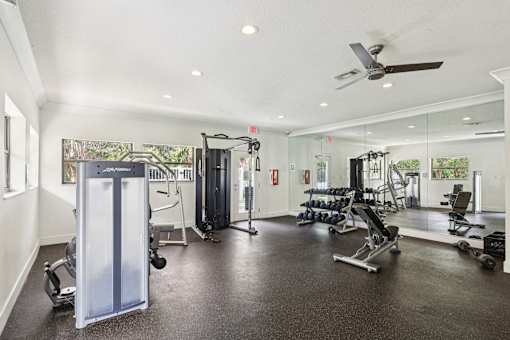 A spacious gym with a variety of equipment including a squat rack, bench, and weights. at Lakeside Glen Apartments, Melbourne, 32904