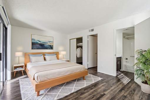 A bedroom with a large bed and a painting on the wall at Del Coronado Apartment , Mesa, 85202