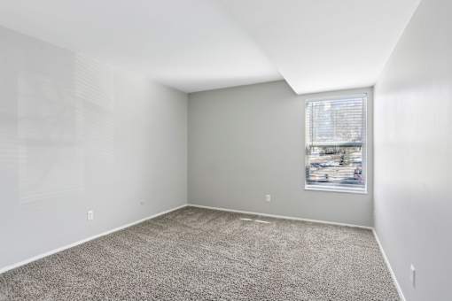 A room with a carpeted floor and a window with blinds. at Millennium at Creve Coeur, Missouri, 63141