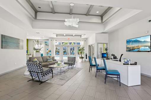 Modern clubhouse lobby with seating and reception desk at The Arbor Walk Apartments, Florida