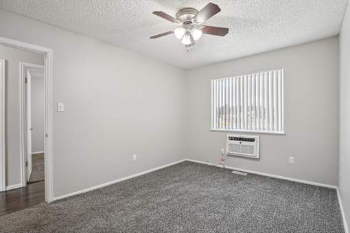 A room with a ceiling fan and a window with blinds.at Aspen Townhomes, Colorado Springs, 80909