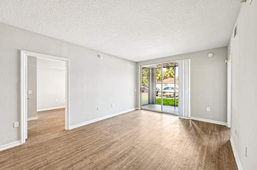 A room with a sliding glass door leading to a balcony. at Heritage Bay, Jensen Beach, FL