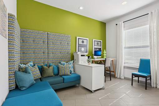 Living room with blue sofa and yellow accent wall at The Arbor Walk Apartments, Tampa, FL 33617