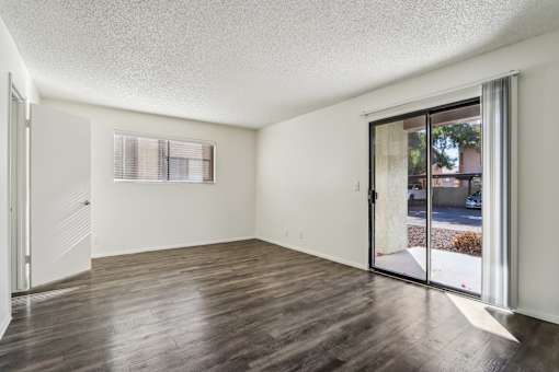 A room with wooden floors and a sliding glass door at Del Coronado Apartment , Mesa, AZ