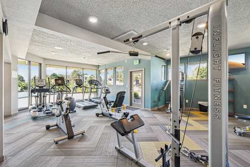 A gym with a variety of equipment including treadmills, exercise bikes, and weight machines at Union Heights Apartments, Colorado Springs, Colorado