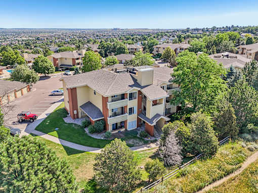A bird's eye view of a residential area with apartment buildings and greenery.