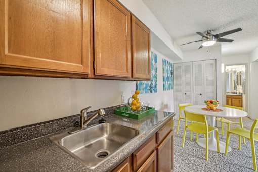 A kitchen with a sink and yellow chairs at Spyglass Creek, Denver, 80224