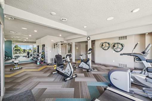 A gym with exercise equipment and a mirror on the wall at Union Heights Apartments, Colorado Springs, Colorado