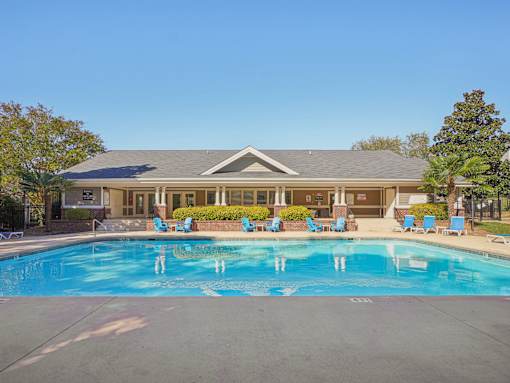 A large swimming pool in front of a building with a blue sky in the background. at Cedar Springs Apartments, Raleigh, 27609