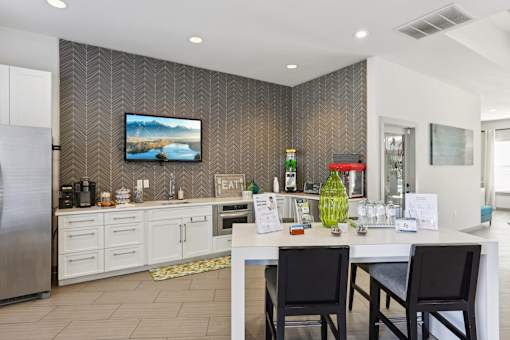 Community kitchen with white cabinetry and beverage station at The Arbor Walk Apartments, Tampa