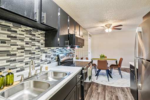 A kitchen with a dining table and chairs in the middle of the room.