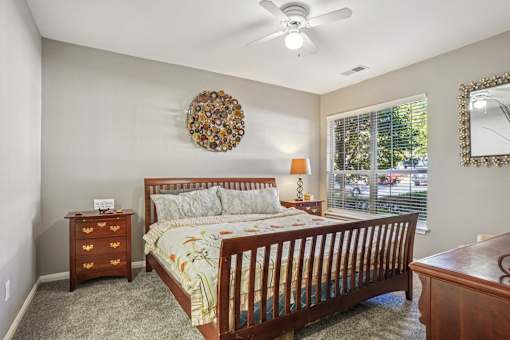 A bedroom with a bed, dresser, and mirror. at Bridford Lake Apartments, North Carolina