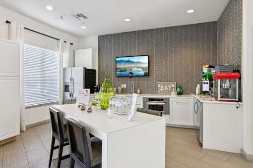 Modern kitchen with island seating and chevron accent wall at The Arbor Walk Apartments, Florida
