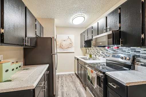 A kitchen with black cabinets and a white countertop.