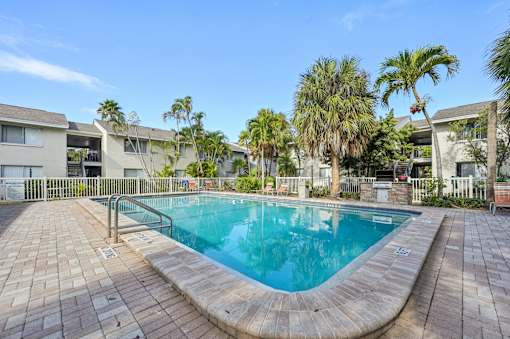 A small pool surrounded by a brick patio. at Sarasota South Apartments, Bradenton, FL