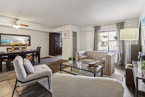 A living room with a beige couch, a glass coffee table, and a chair at Del Coronado Apartment, Mesa, AZ, 85202