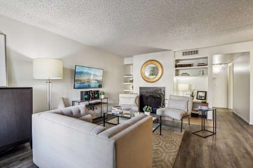 A living room with a fireplace and a painting on the wall at Del Coronado Apartment , Mesa, Arizona