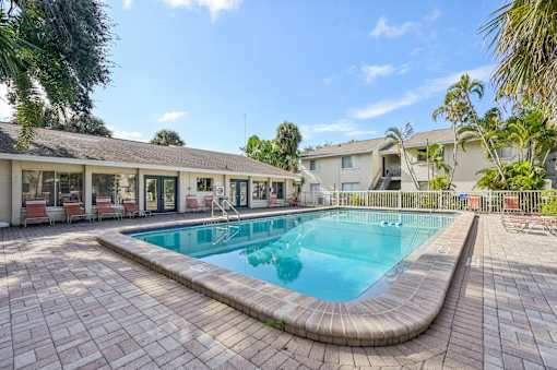 A swimming pool surrounded by a brick patio. at Sarasota South Apartments, Florida, 34207