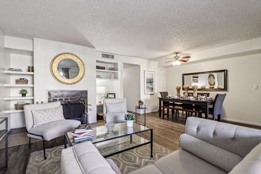 A living room with a grey couch, a glass coffee table, and a fireplace at Del Coronado Apartment , Arizona