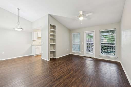 A room with a ceiling fan and a window with blinds.