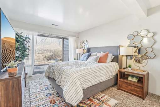 A bedroom with a large bed and a view of the mountains outside the window. at Cliffs at Canyon Ridge, Utah, 84401