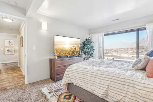 A bedroom with a large bed and a view of the mountains outside the window. at Cliffs at Canyon Ridge, Utah, 84401